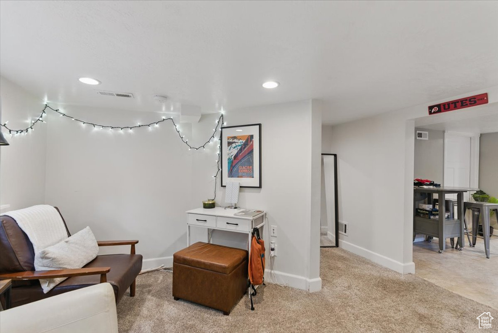 Living area featuring baseboards, light colored carpet, and recessed lighting