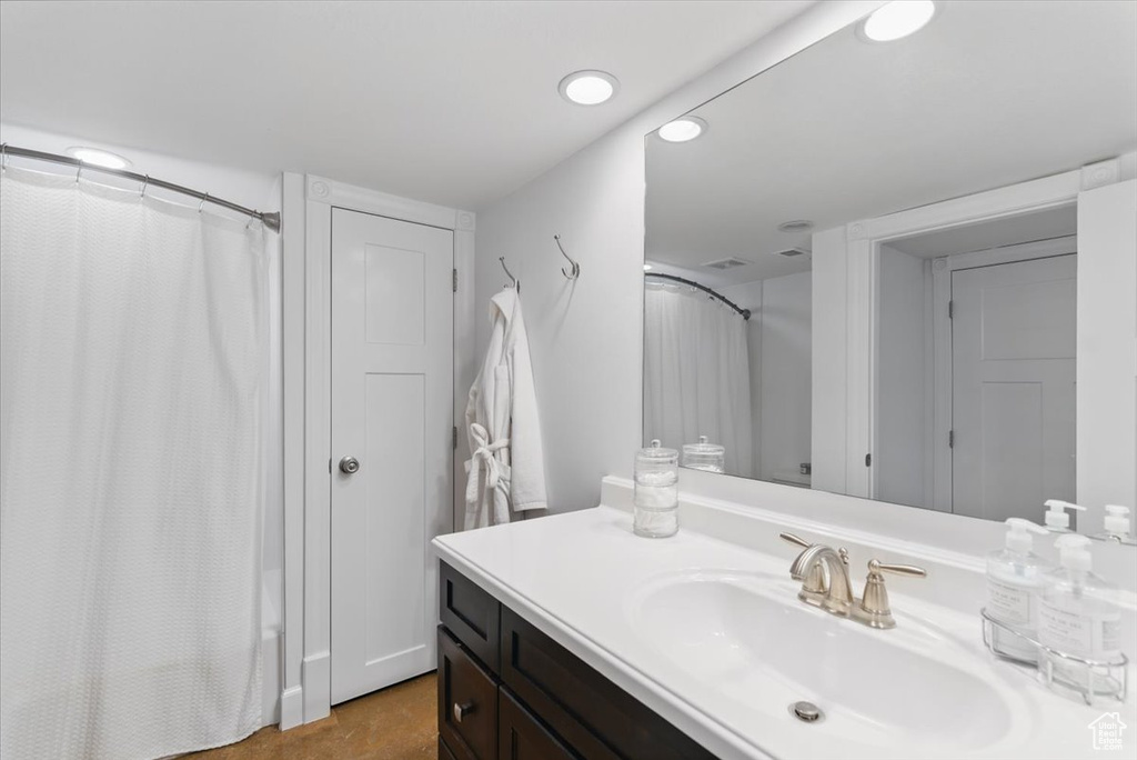 Full bath with vanity, curtained shower, and recessed lighting