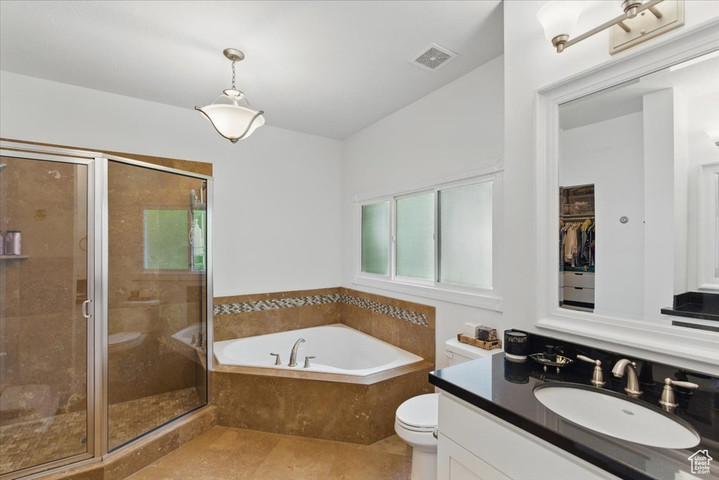 Full bath featuring vanity, a bath, toilet, a stall shower, and tile patterned floors