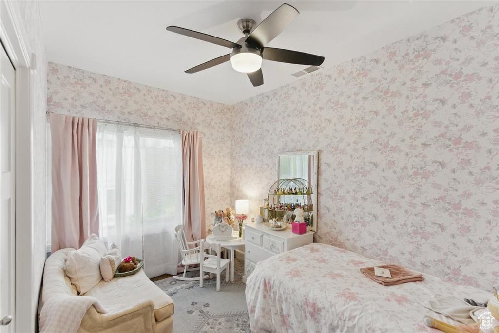 Bedroom featuring wallpapered walls, carpet flooring, and a ceiling fan