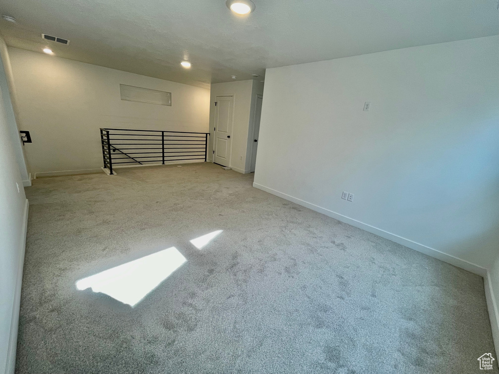 Carpeted empty room with baseboards and recessed lighting
