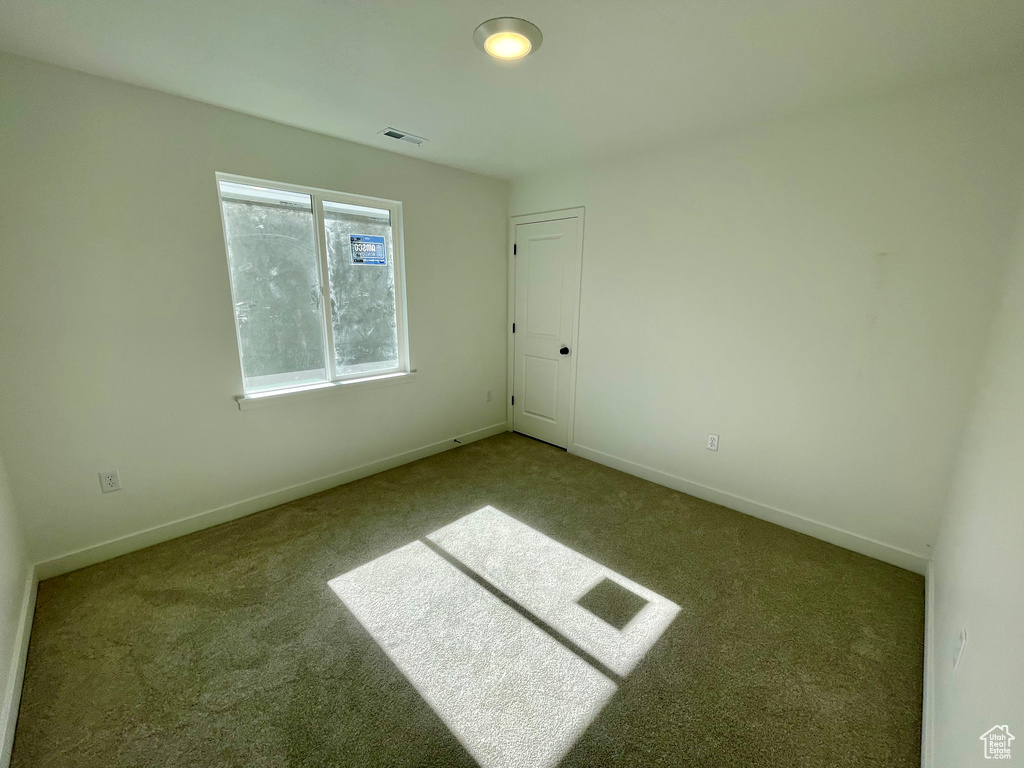 Carpeted empty room featuring baseboards