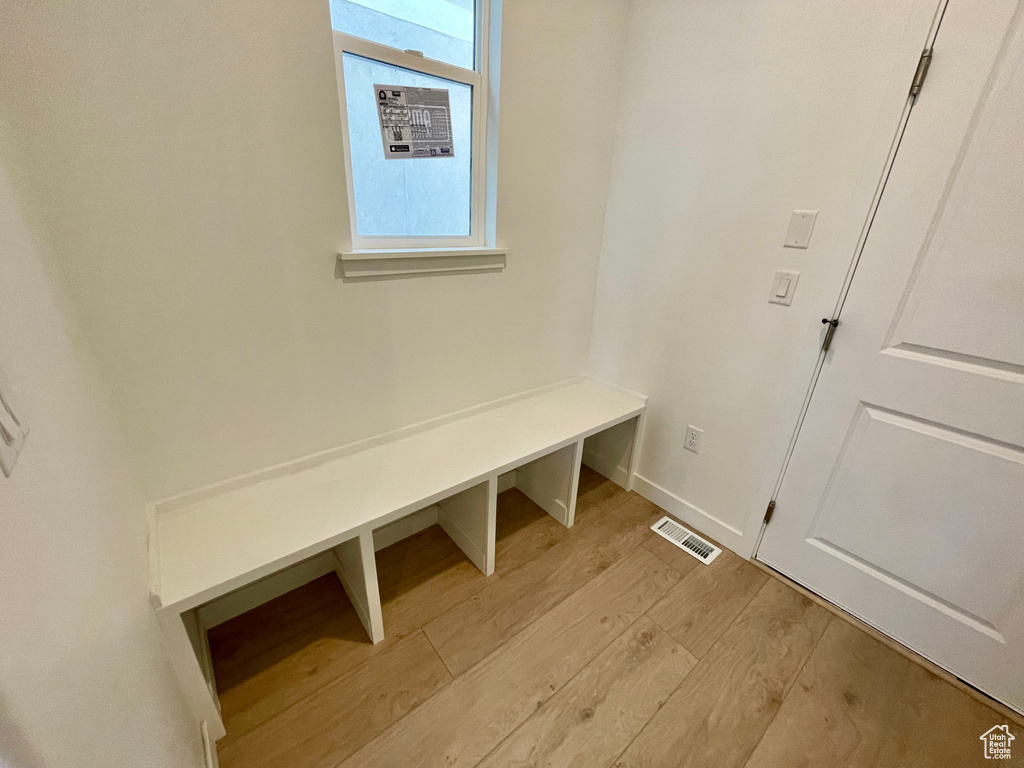 Mudroom with light wood finished floors and baseboards