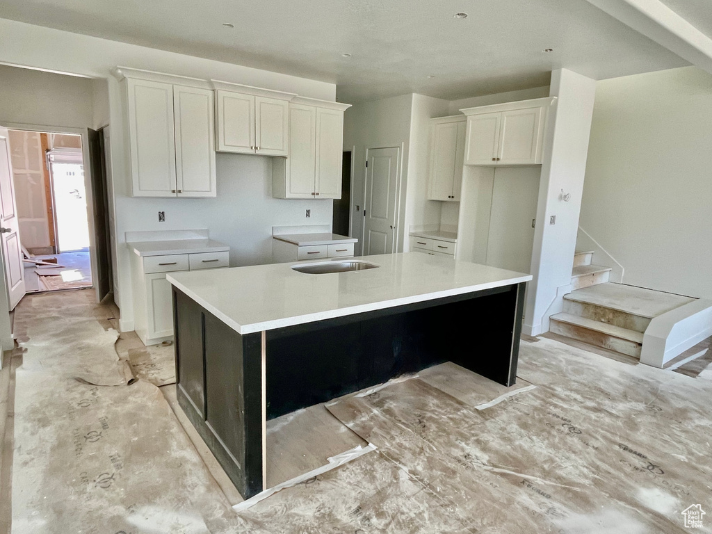 Kitchen with a large island, white cabinetry, and a sink