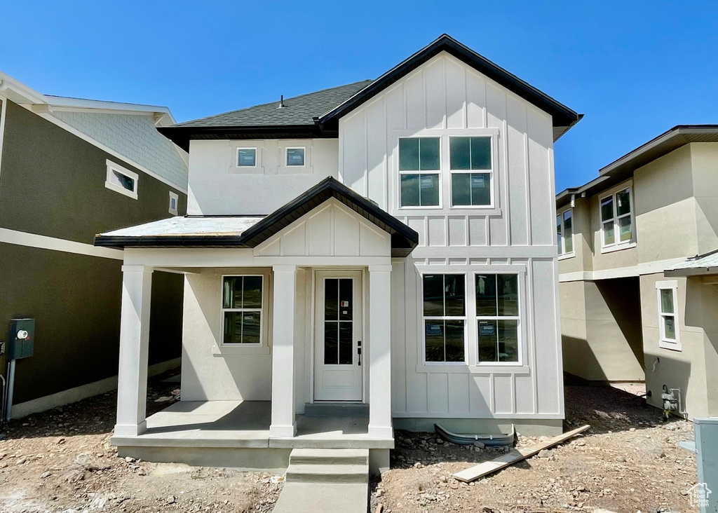 View of front facade featuring board and batten siding and a porch
