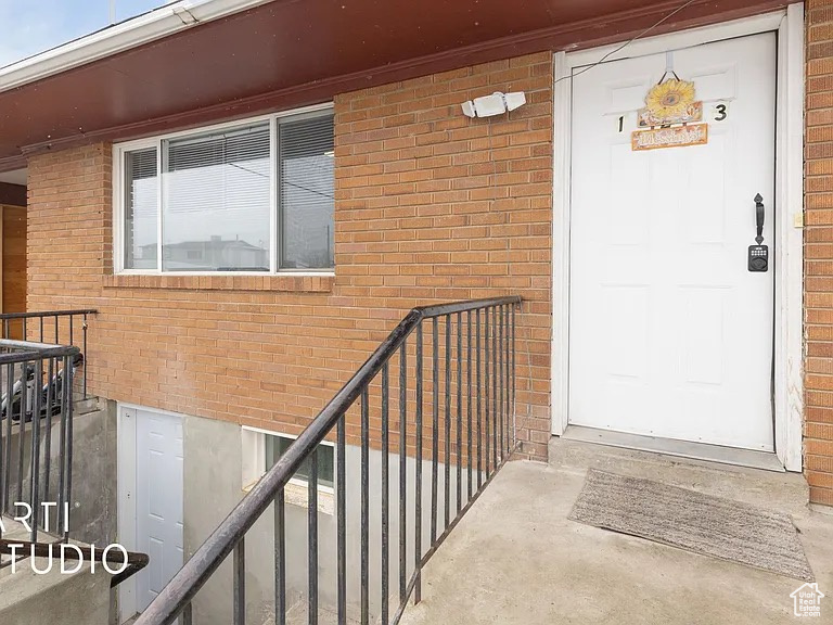 View of exterior entry with brick siding