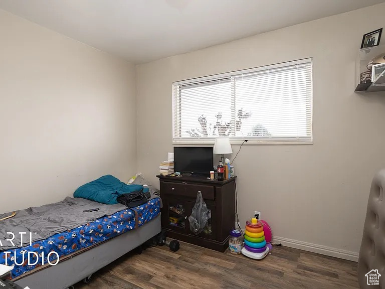 Bedroom featuring wood finished floors and baseboards