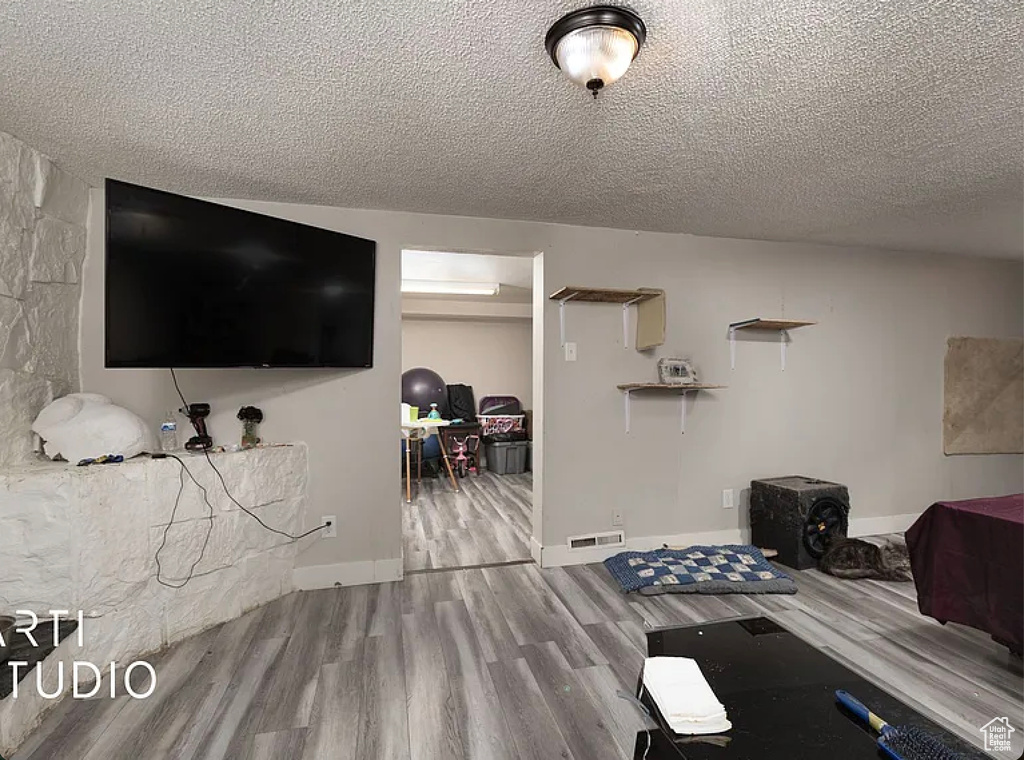 Exercise room featuring wood finished floors and a textured ceiling