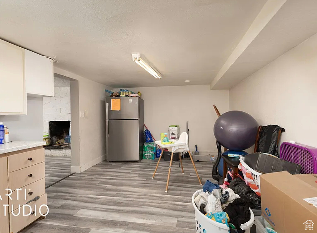 Playroom featuring light wood-type flooring, baseboards, and a fireplace