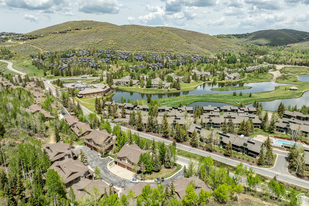 Aerial view of property's location featuring a water and mountain view and nearby suburban area