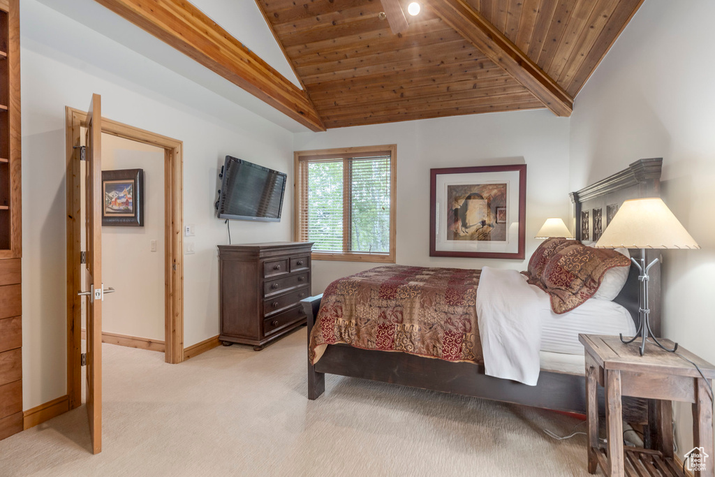 Bedroom featuring vaulted ceiling, light colored carpet, wood ceiling, and baseboards