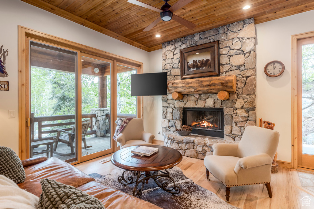 Living area with wood ceiling, a ceiling fan, a fireplace, wood finished floors, and baseboards