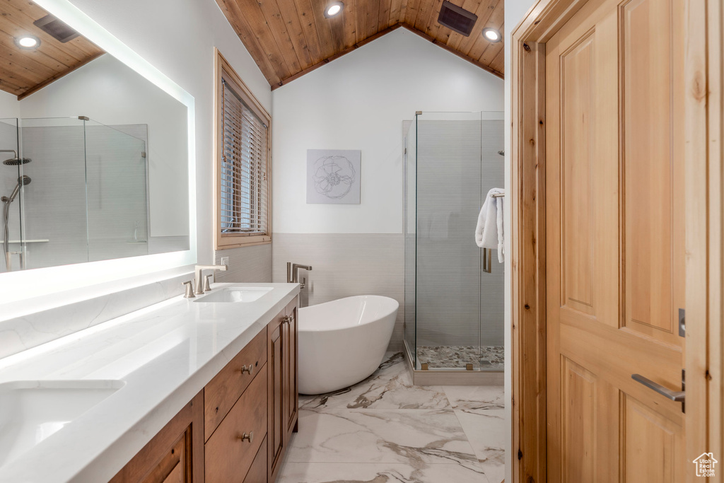 Bathroom with wooden ceiling, marble look tile flooring, lofted ceiling, recessed lighting, and a freestanding bath
