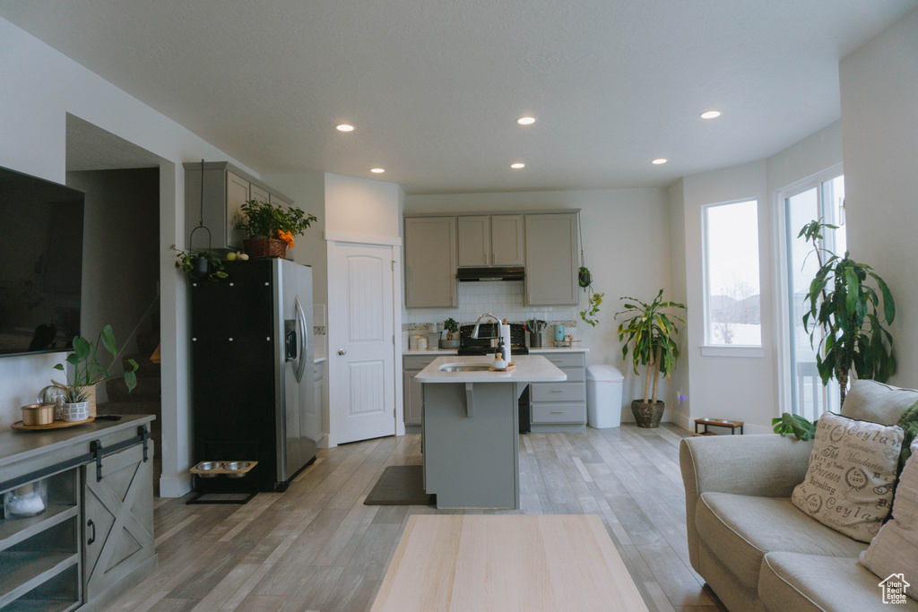Living room with light wood-style flooring and recessed lighting