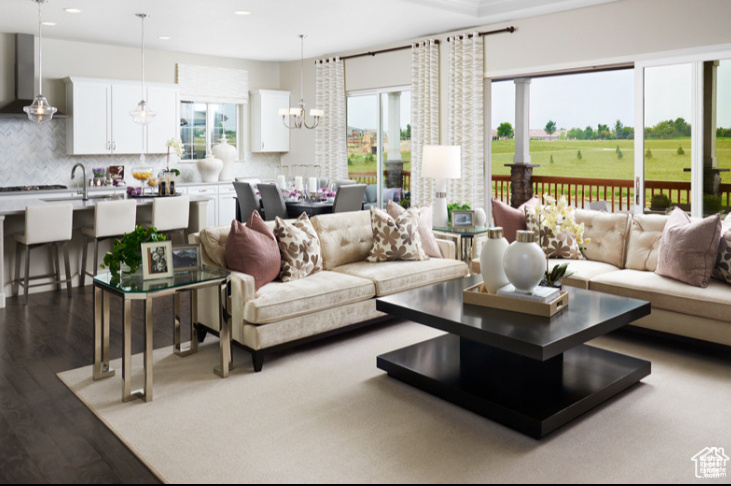 Living area with recessed lighting, plenty of natural light, dark wood-type flooring, and a chandelier