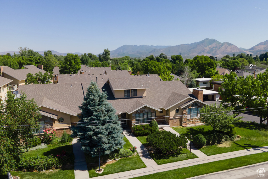 View of front of house with a residential view, stone siding, a mountain view, and roof with shingles