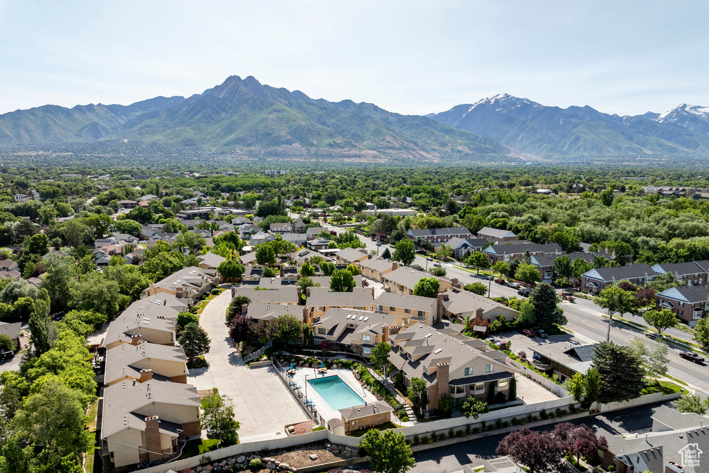 Aerial view of residential area featuring a mountain backdrop and a pool area