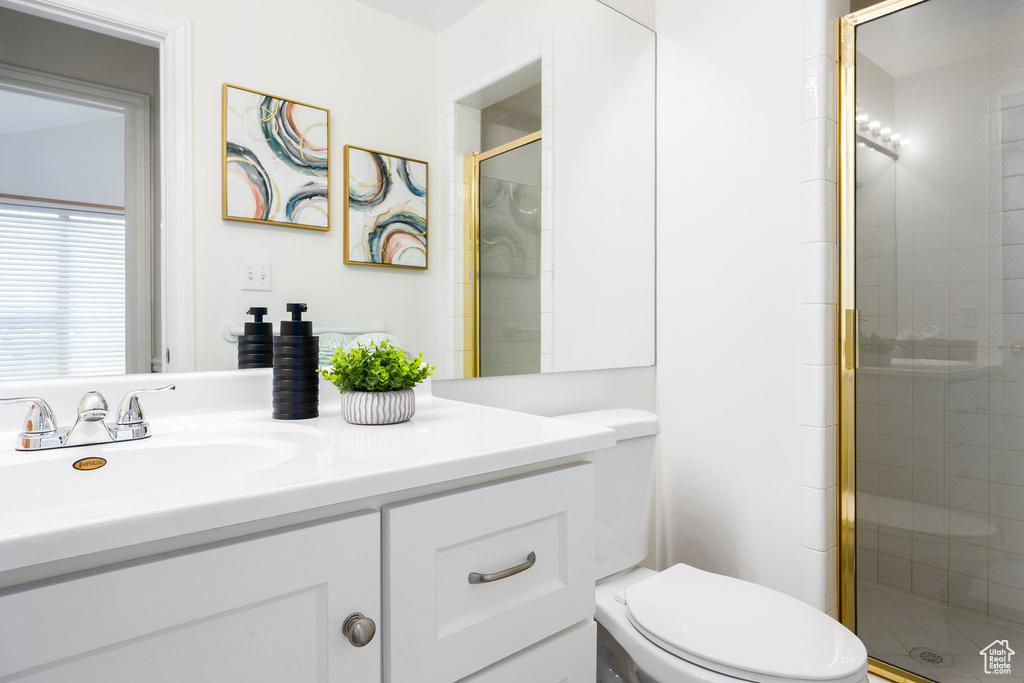 Bathroom with vanity, a stall shower, and toilet