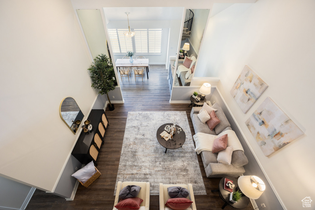 Living room with wood finished floors, a chandelier, and baseboards