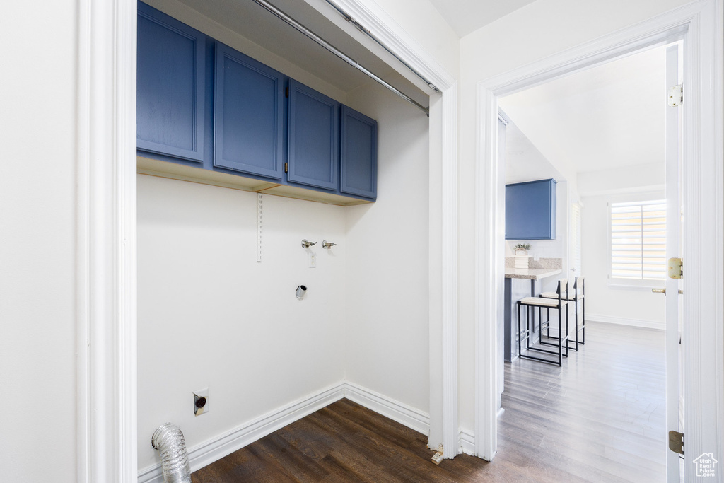 Laundry area featuring hookup for an electric dryer, dark wood-style flooring, cabinet space, and baseboards