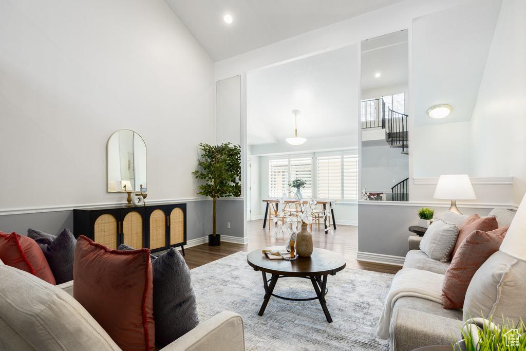 Living area featuring high vaulted ceiling, wood finished floors, recessed lighting, and baseboards