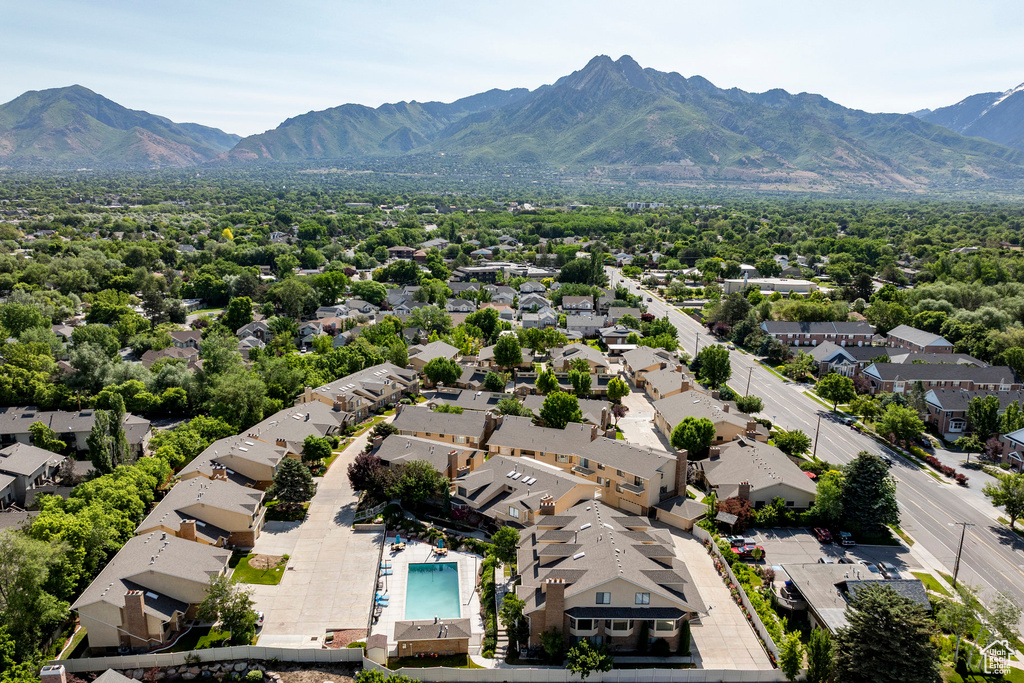 Aerial perspective of suburban area featuring a mountain backdrop and a pool