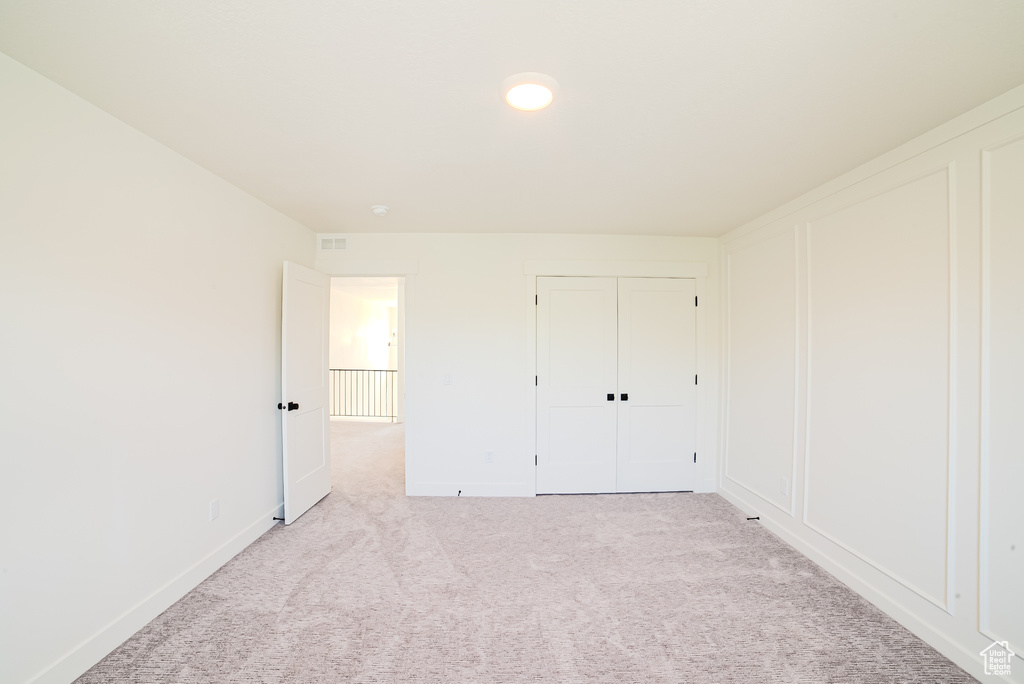 Unfurnished bedroom with carpet floors, baseboards, and a closet