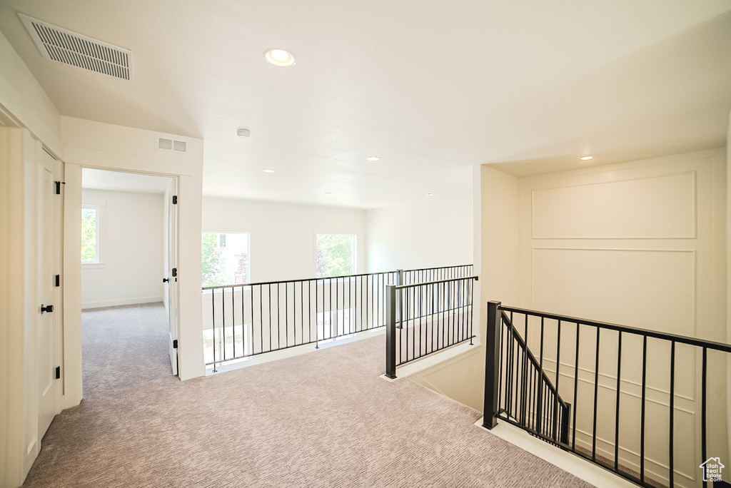 Hall featuring carpet floors, an upstairs landing, healthy amount of natural light, and recessed lighting