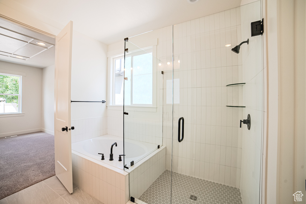 Bathroom with a bath, a shower stall, and tile patterned floors