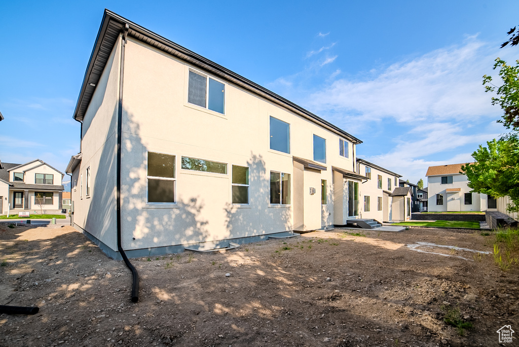 Rear view of property featuring a residential view and stucco siding