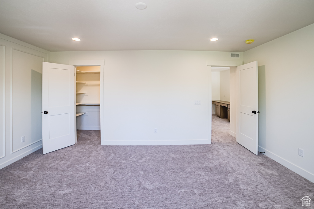 Unfurnished bedroom featuring carpet floors, recessed lighting, a spacious closet, and baseboards
