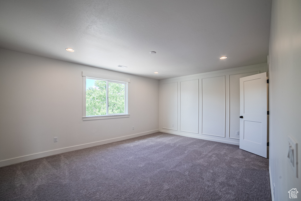 Empty room featuring carpet floors, recessed lighting, and baseboards