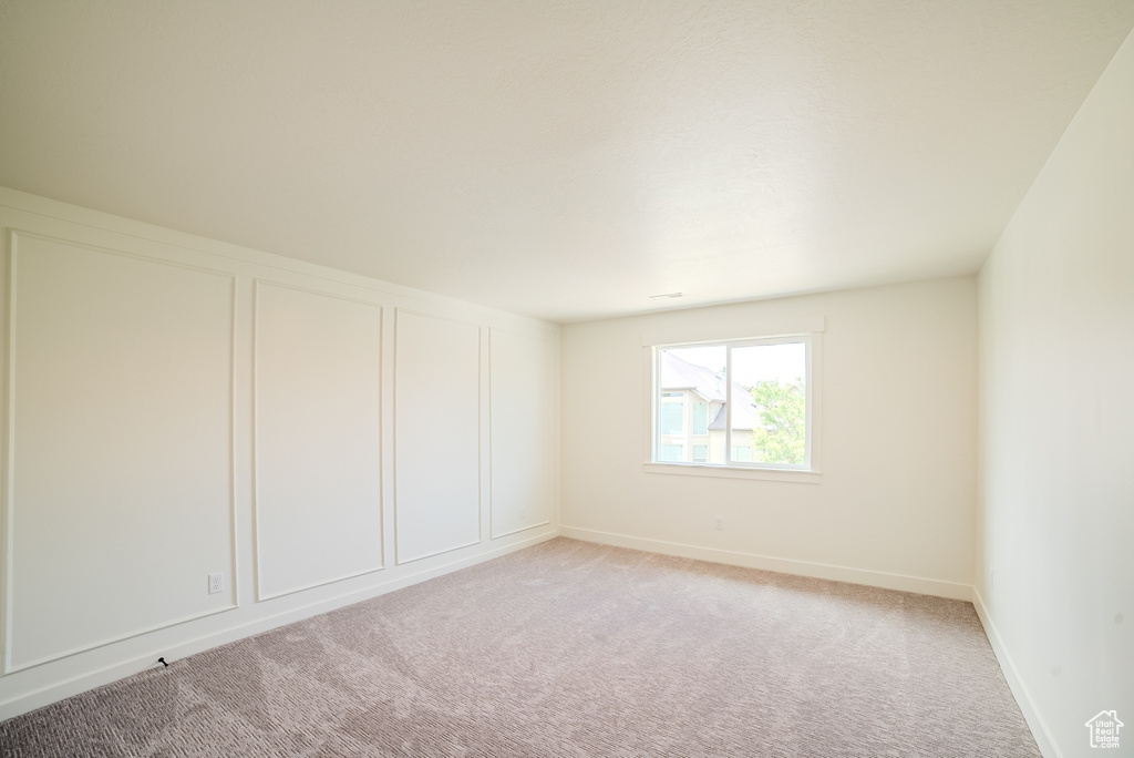 Spare room with light carpet and baseboards