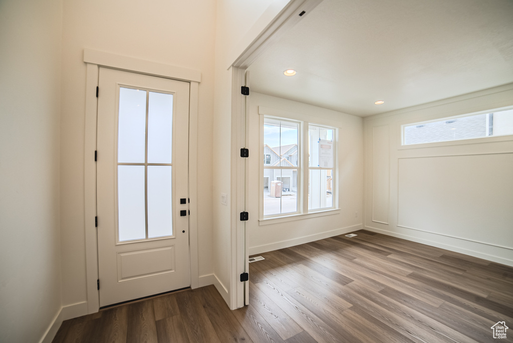 Doorway to outside with dark wood-type flooring, baseboards, and recessed lighting