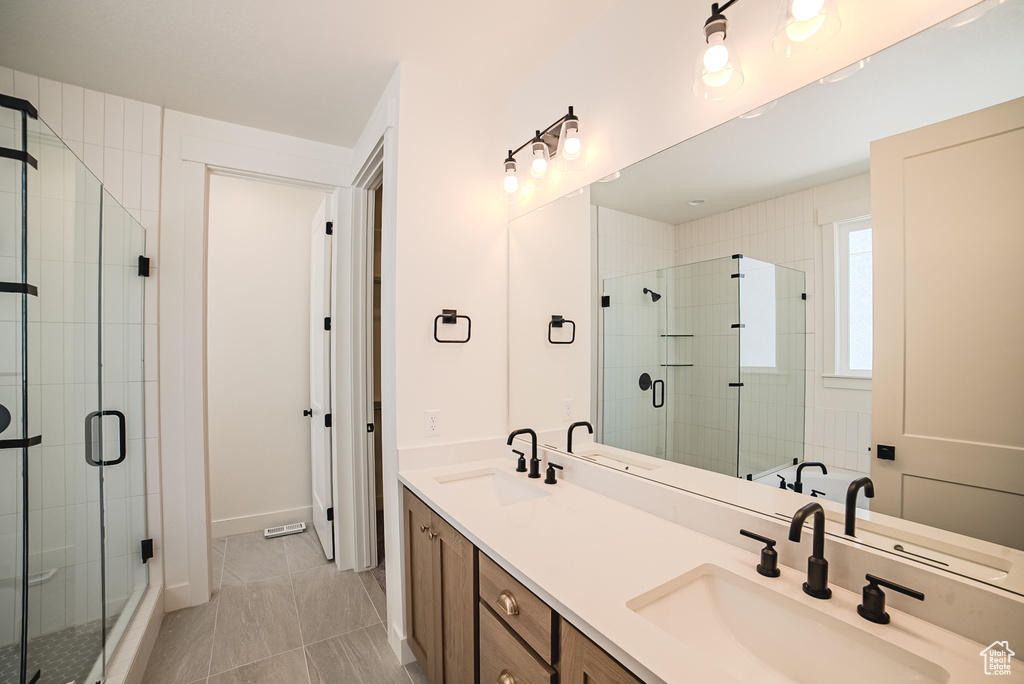 Bathroom featuring double vanity and a shower stall