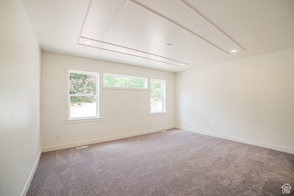 Carpeted empty room featuring healthy amount of natural light, attic access, baseboards, and recessed lighting