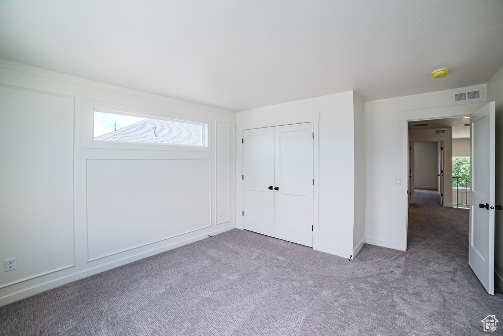 Unfurnished bedroom featuring carpet, a closet, and baseboards