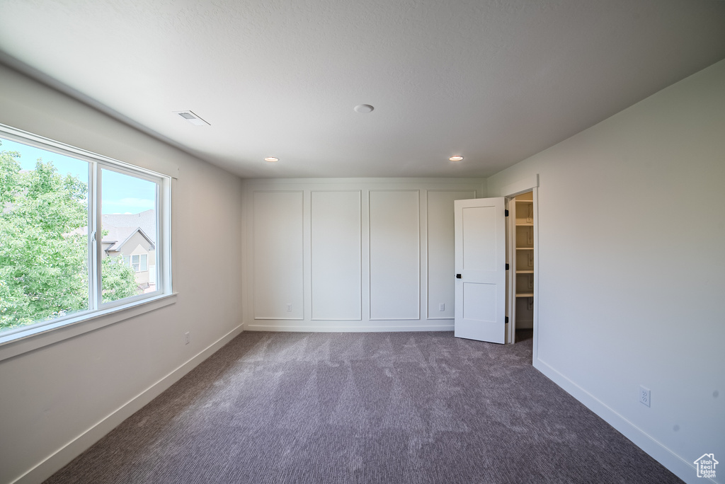 Unfurnished bedroom with baseboards, dark colored carpet, and recessed lighting