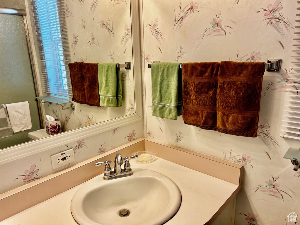 Bathroom with vanity and wallpapered walls