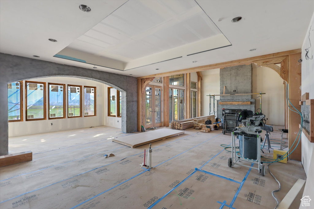 Living area featuring a tray ceiling and arched walkways