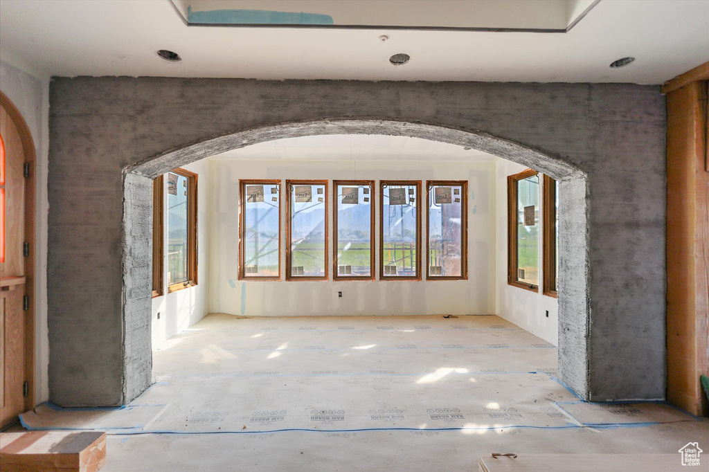 Unfurnished room featuring arched walkways