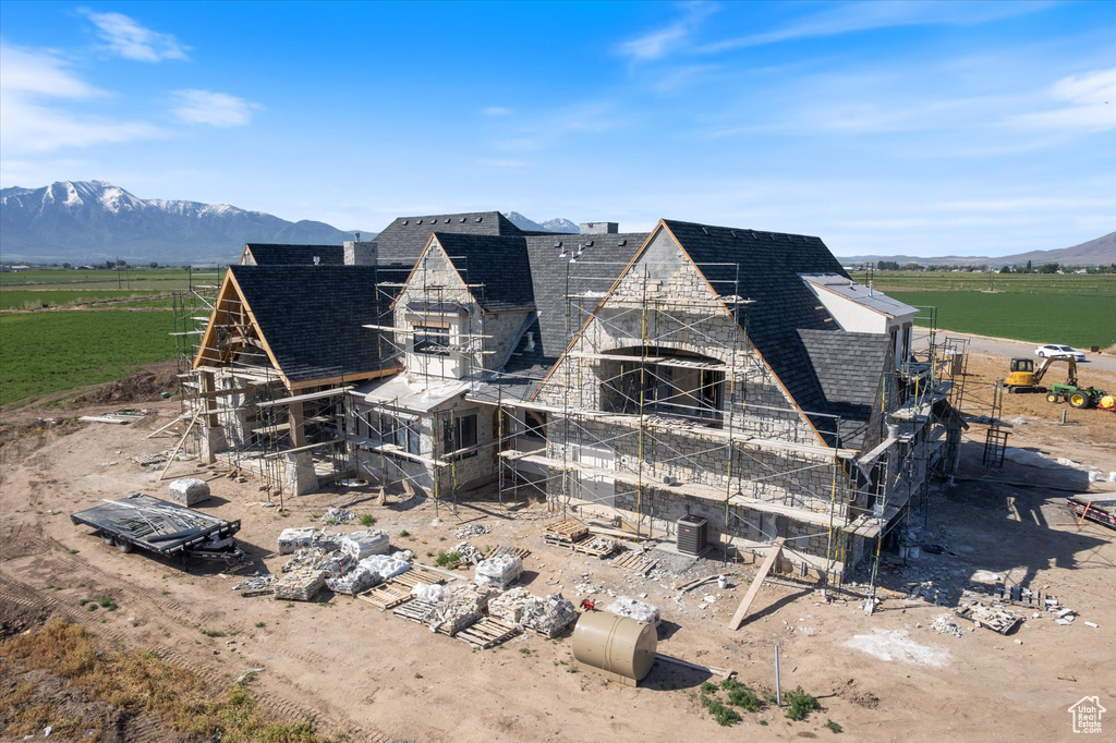 Rear view of property with a shingled roof, a rural view, a mountain view, and a chimney