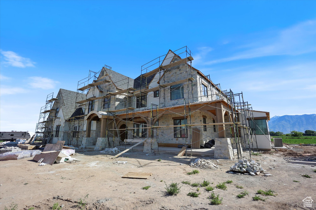 Rear view of property featuring stone siding and a mountain view