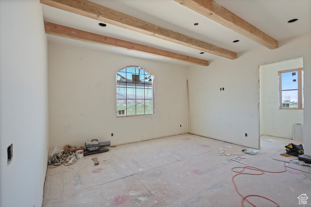 Empty room with beamed ceiling
