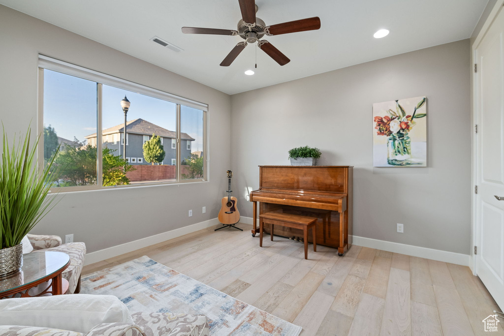 Sitting room with light wood-style flooring, ceiling fan, baseboards, and recessed lighting
