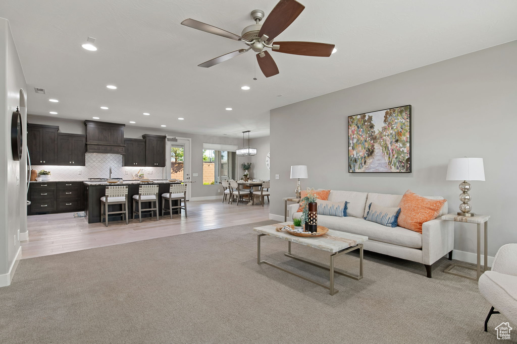 Living area with recessed lighting, baseboards, ceiling fan, and light colored carpet