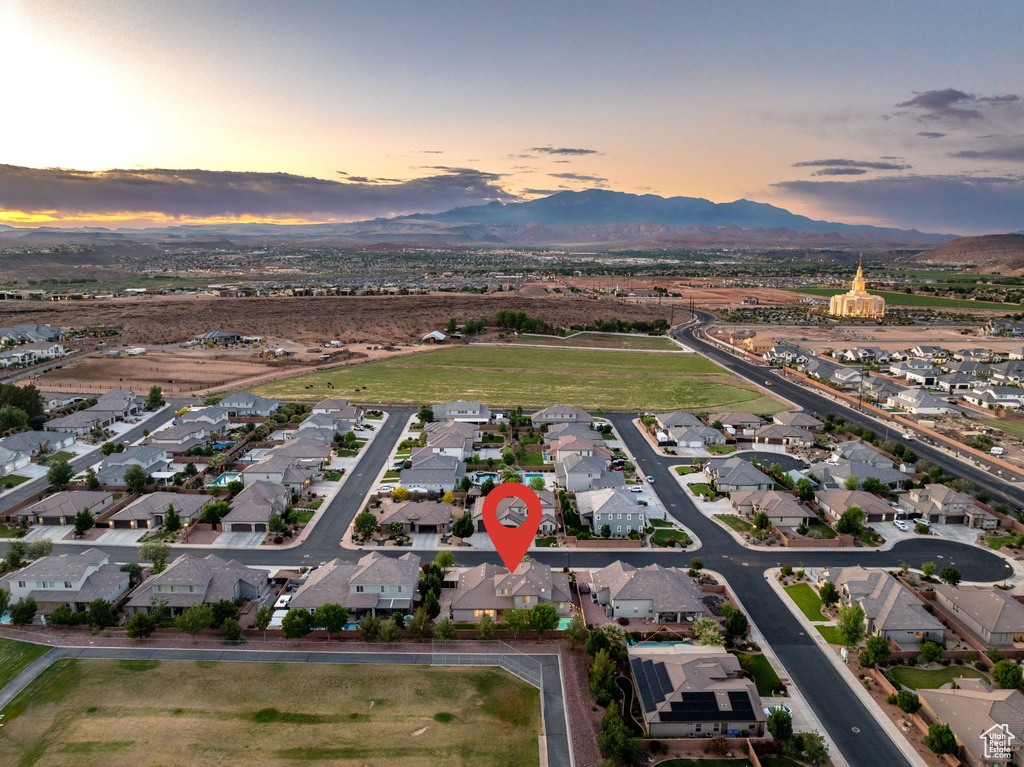 Aerial view of property and surrounding area with mountains and nearby suburban area