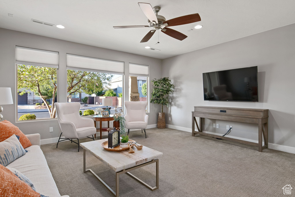 Carpeted living area featuring baseboards, recessed lighting, and a ceiling fan