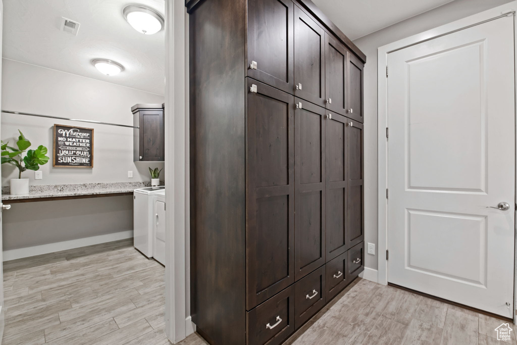 Mudroom with washing machine and clothes dryer, light wood finished floors, and baseboards