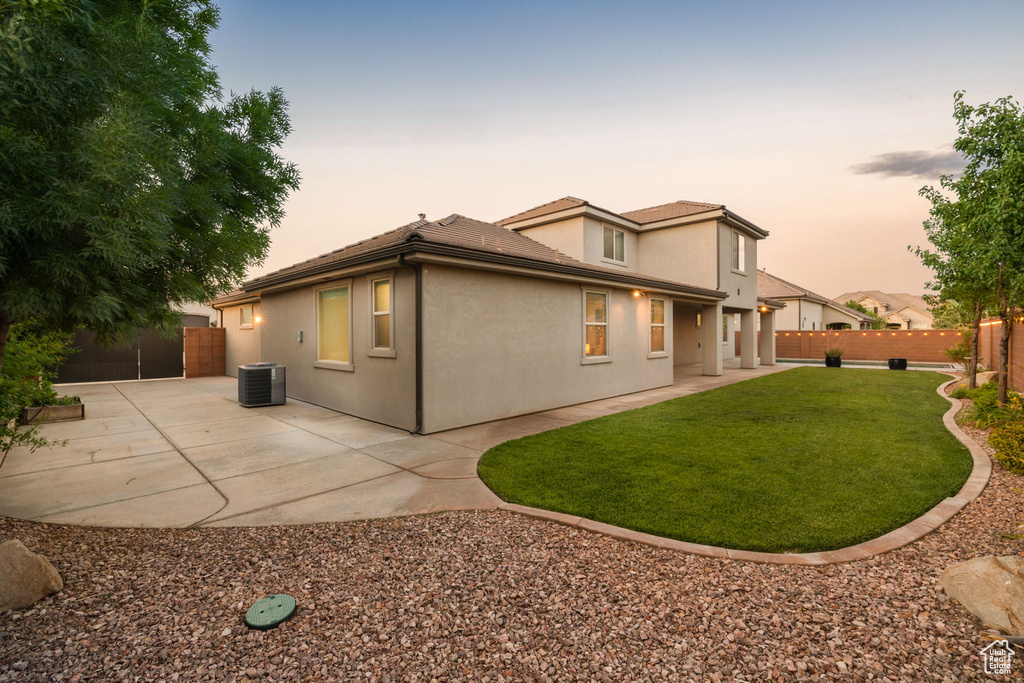 Rear view of house featuring central air condition unit, a patio area, and stucco siding